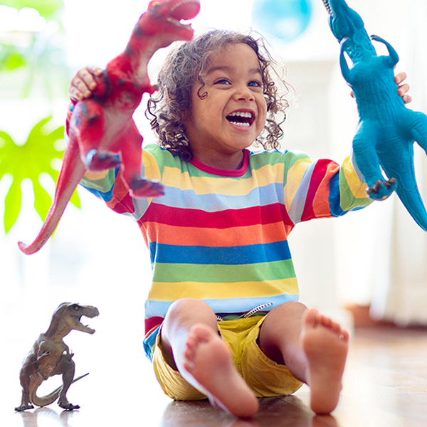 Child,Playing,With,Colorful,Toy,Dinosaurs.,Educational,Toys,For,Kids. Child playing with colorful toy dinosaurs. Educational toys for kids. Little boy learning fossils and reptiles. Children play with dinosaur toys. Evolution and paleontology game for young kid.